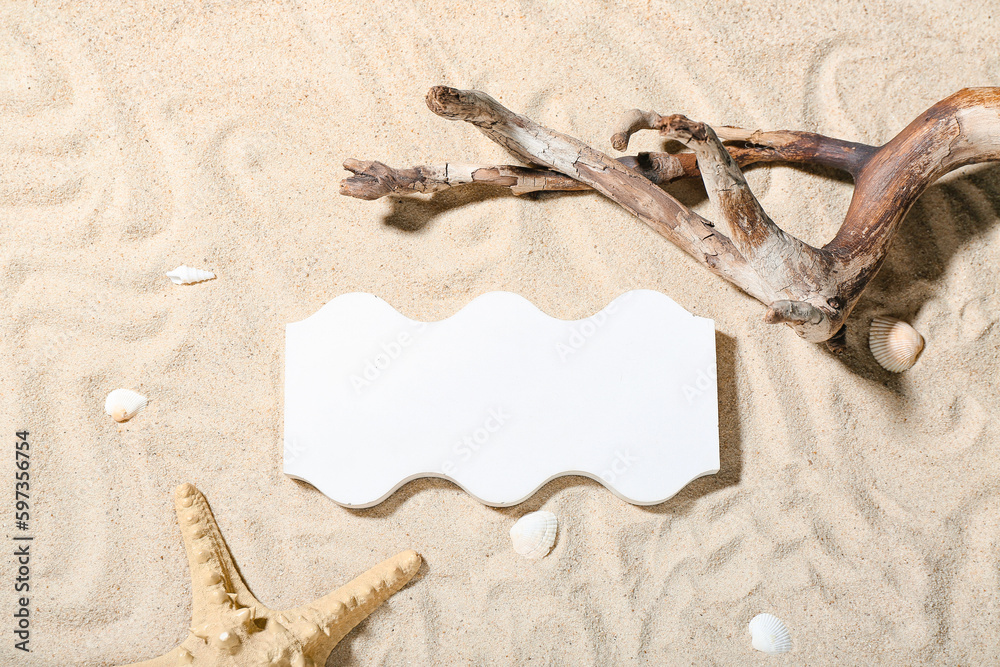 Decorative plaster podium, seashells, starfish and tree branch in sand