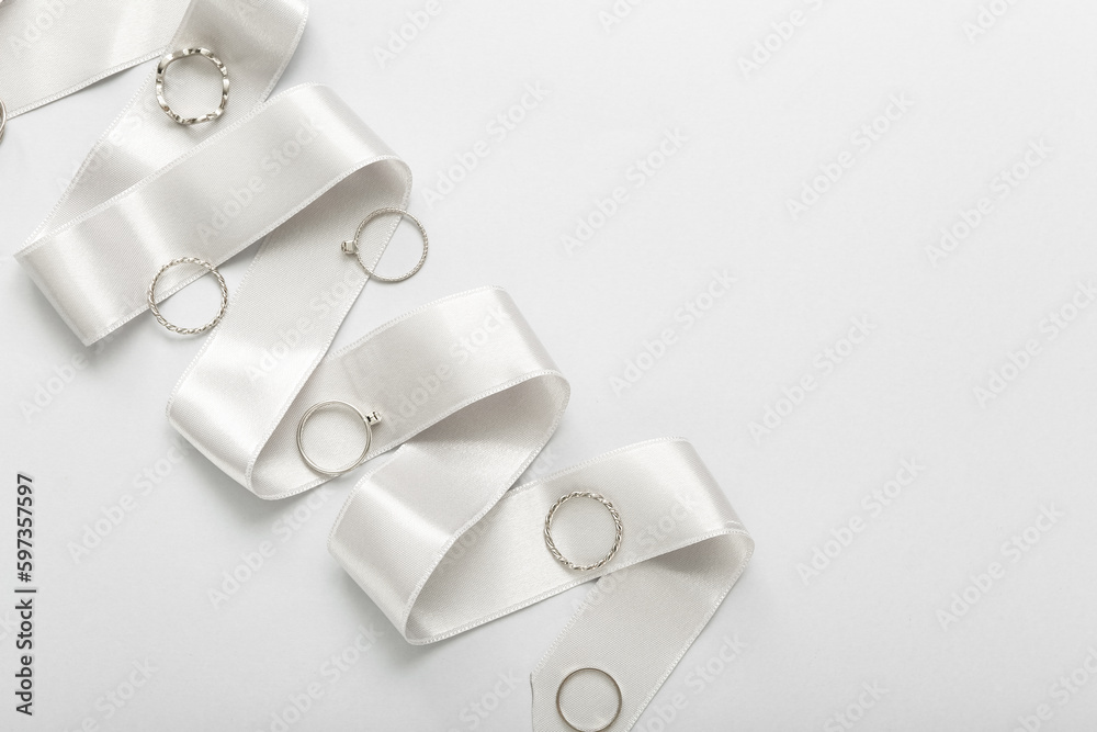 Ribbon with silver rings on light background