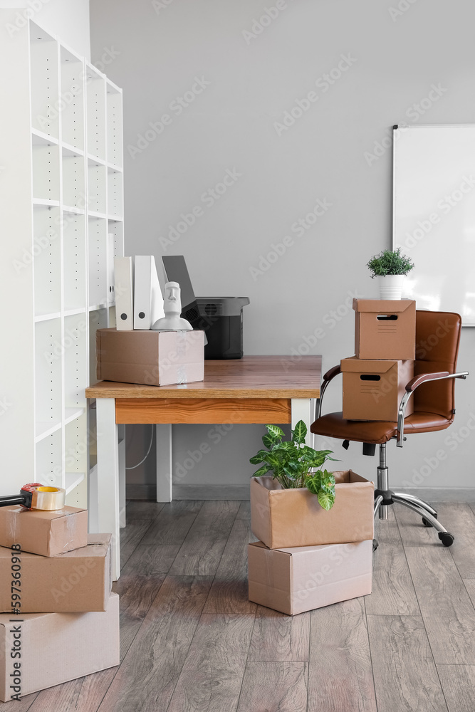 Workplace with cardboard boxes in office on moving day