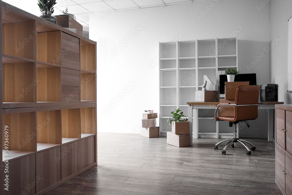 Workplace with cardboard boxes in office on moving day