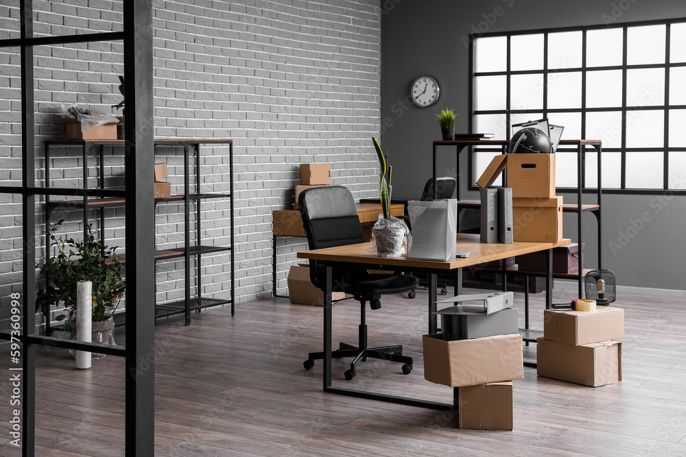 Workplace with cardboard boxes in office on moving day