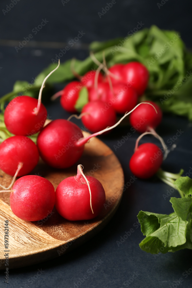 Plate of ripe radish on dark background, closeup