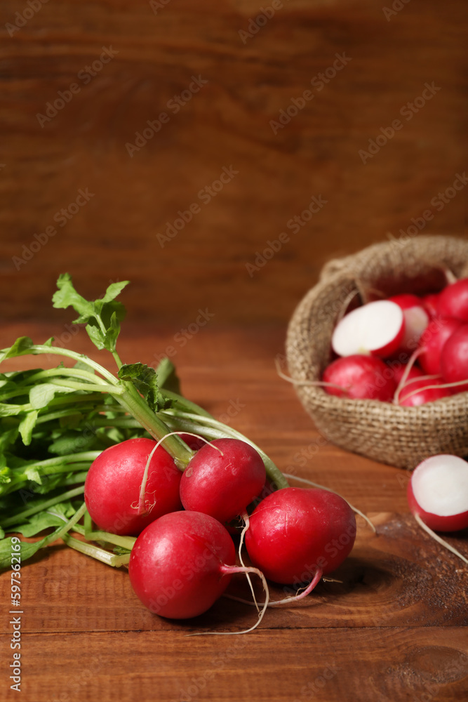 Bunch of ripe radish with green leaves on wooden background