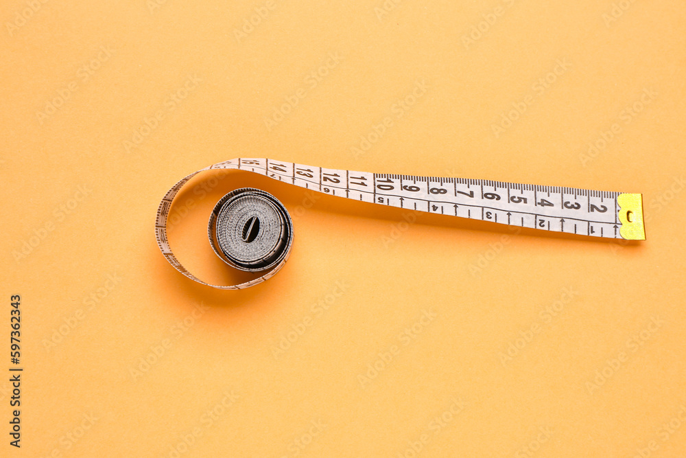 White measuring tape on orange background