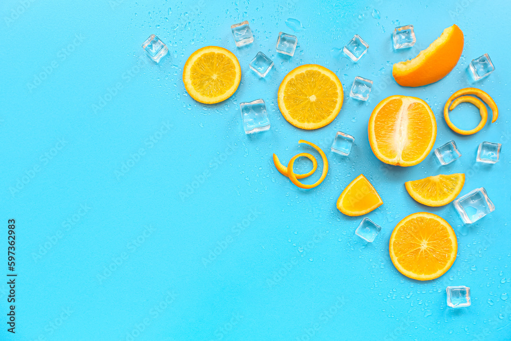 Orange pieces with ice cubes on blue background