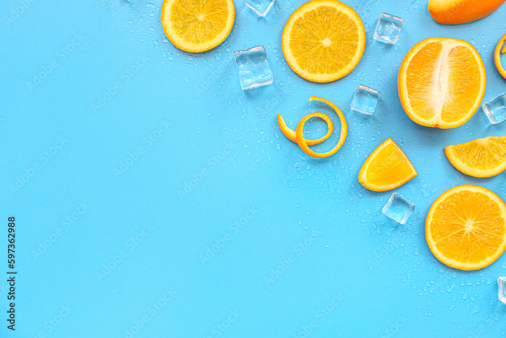 Orange pieces with ice cubes on blue background