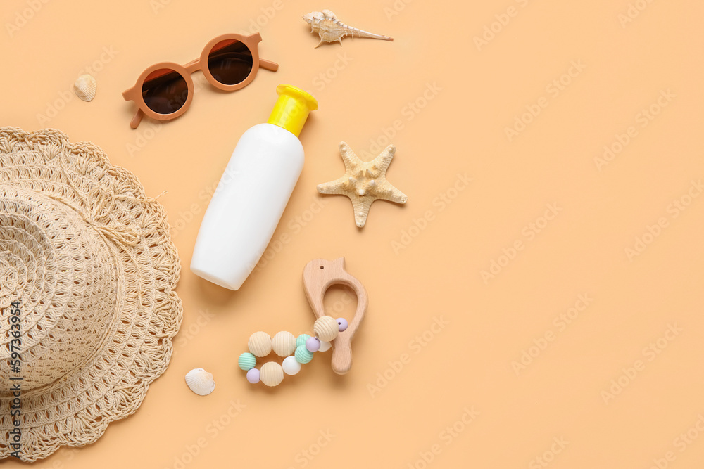 Sunscreen cream for baby with beach accessories on beige background