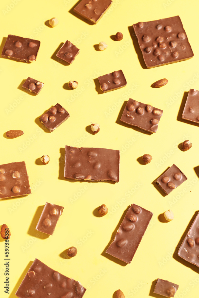 Sweet tasty chocolate with nuts on  yellow background