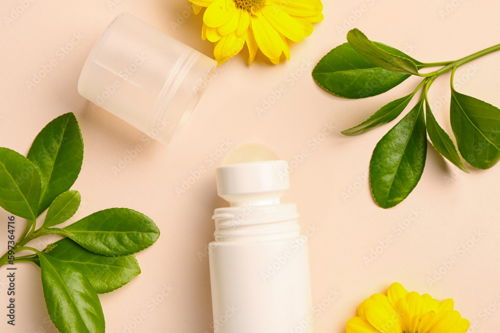 Deodorant with flowers and twigs on beige background