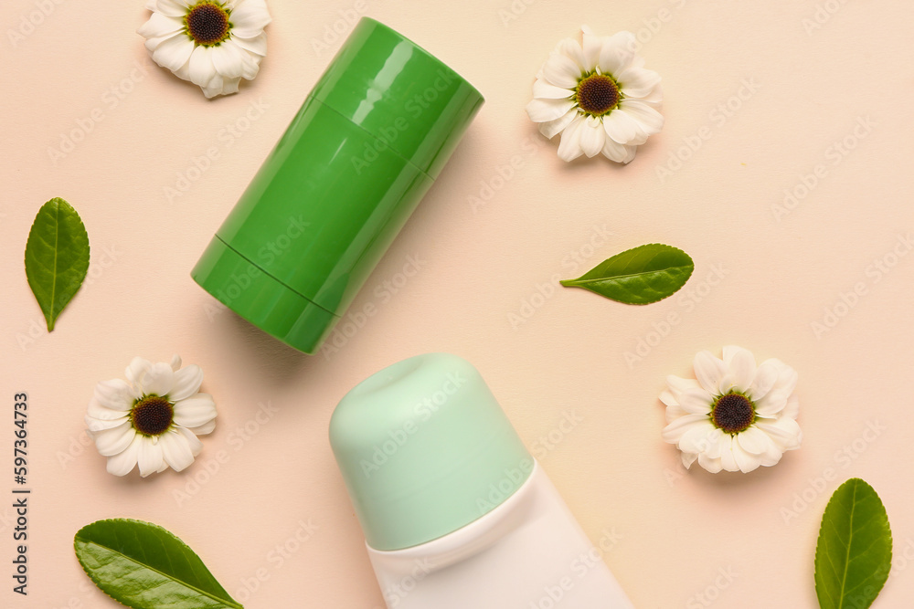 Deodorant with flowers and leaves on beige background