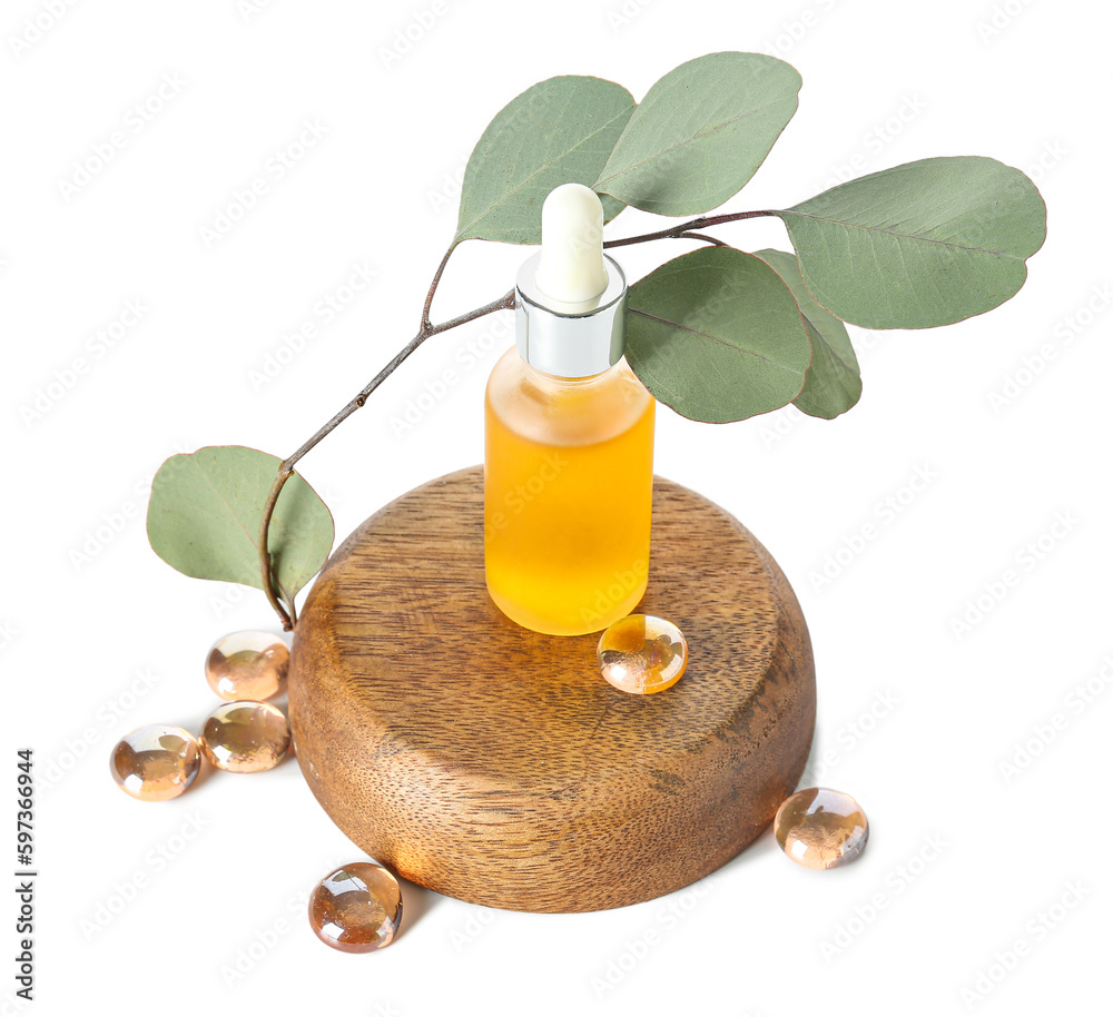 Bottle with cosmetic oil on wooden stand, eucalyptus branch and stones on white background