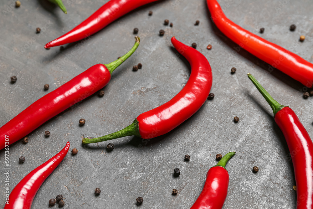 Fresh chili peppers with peppercorns on dark background