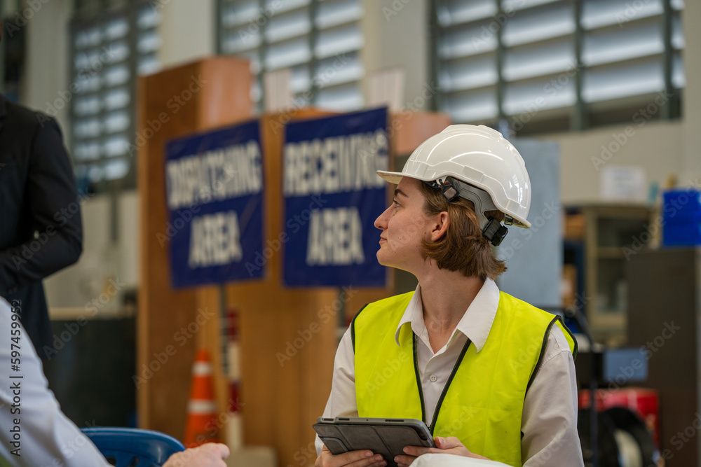 Warehouse managers and worker working together in warehouse office in a large distribution warehouse