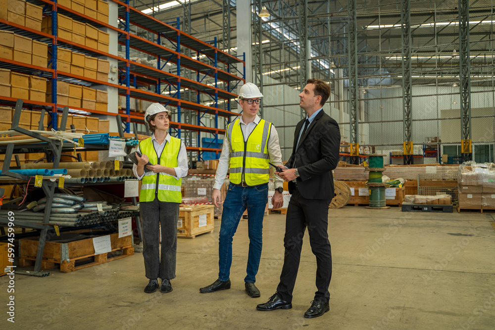 Warehouse manager meeting with his team in a large distribution warehouse.