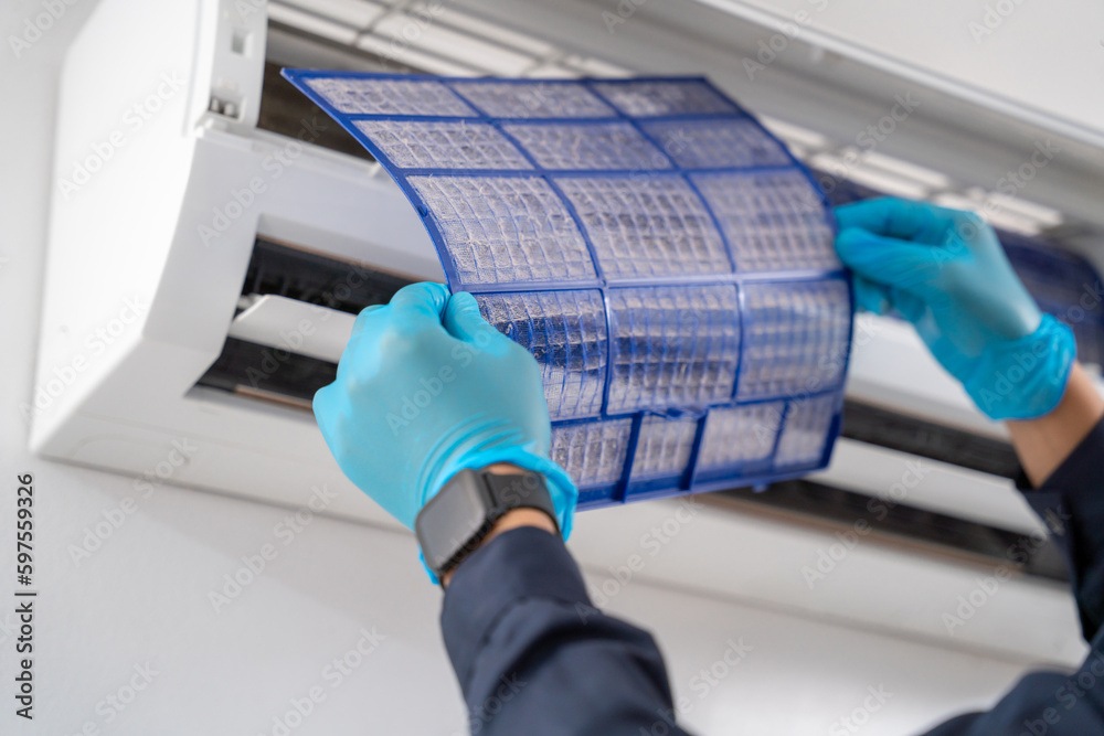 Close-up hand of Air technician service removing air filter of the air conditioner for cleaning on w