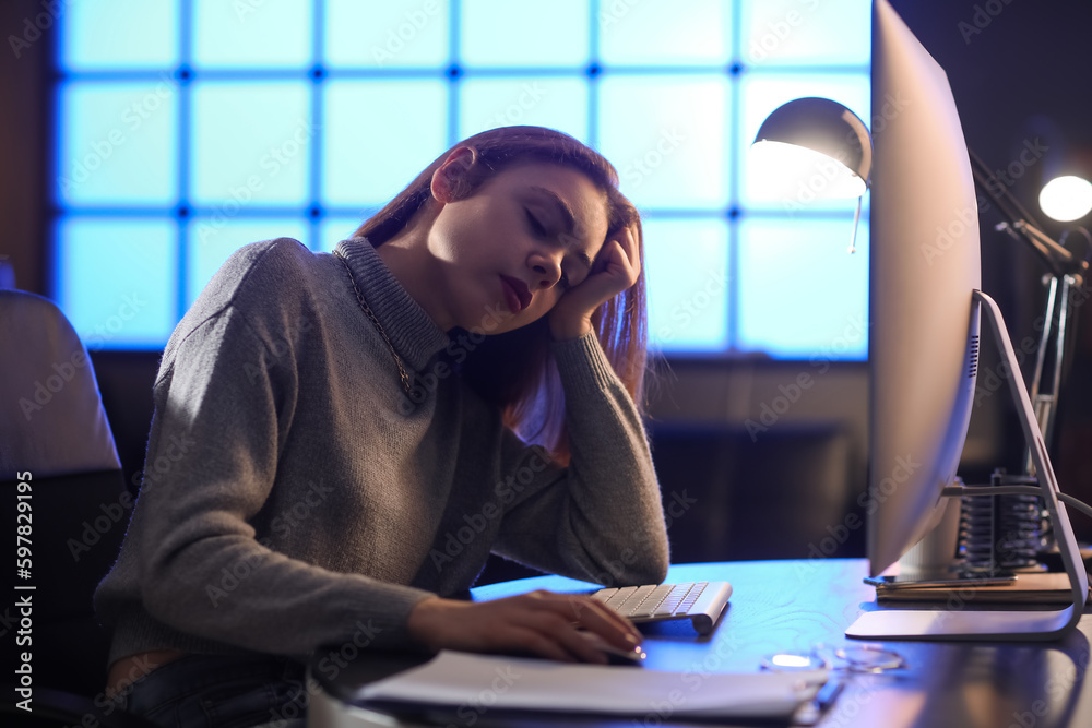 Tired female programmer working in office at night