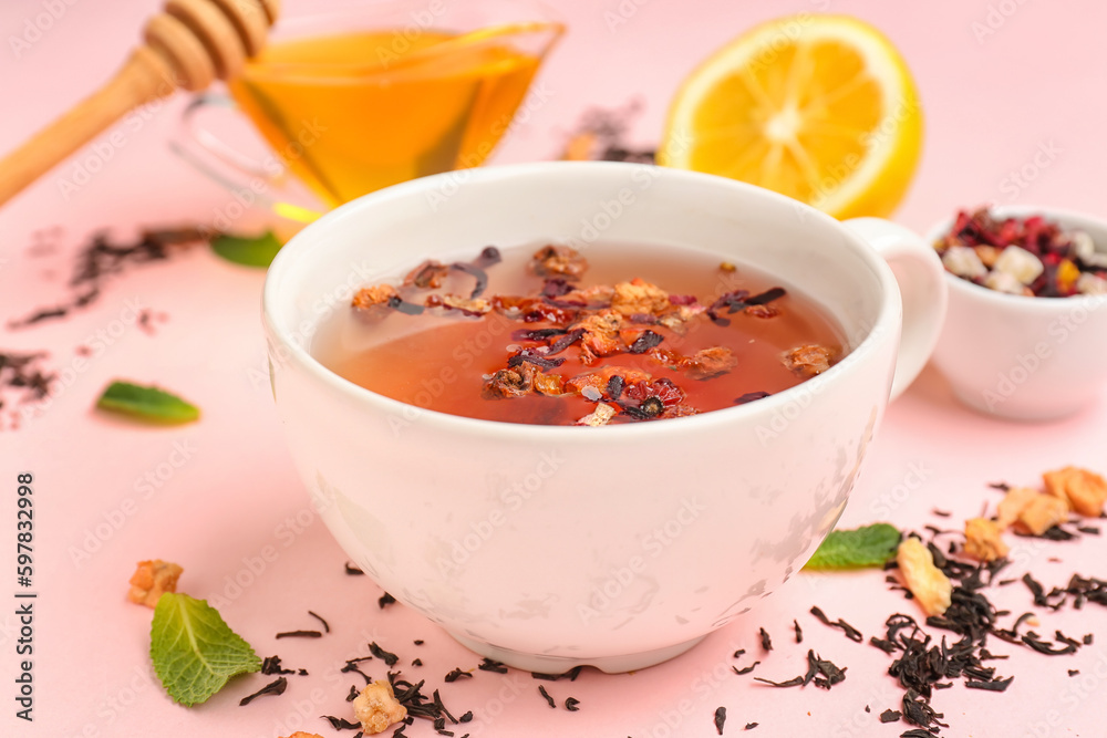 Cup of fruit tea on pink background, closeup