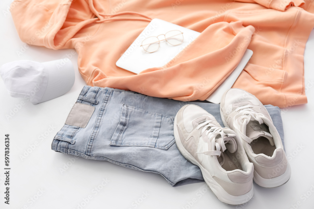 Stylish clothes with accessories, sneakers and laptop on white background, closeup