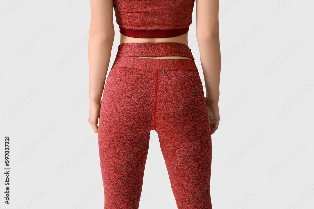 Sporty young woman in leggings on white background, back view