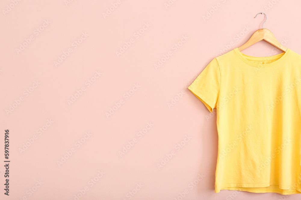 Yellow t-shirt hanging on pink wall