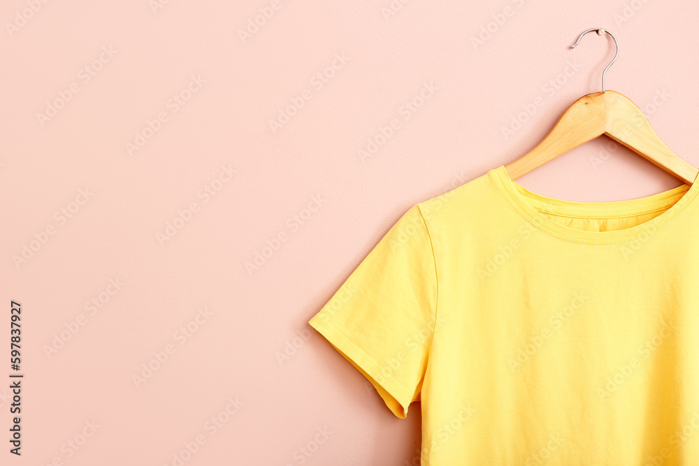 Yellow t-shirt hanging on pink wall