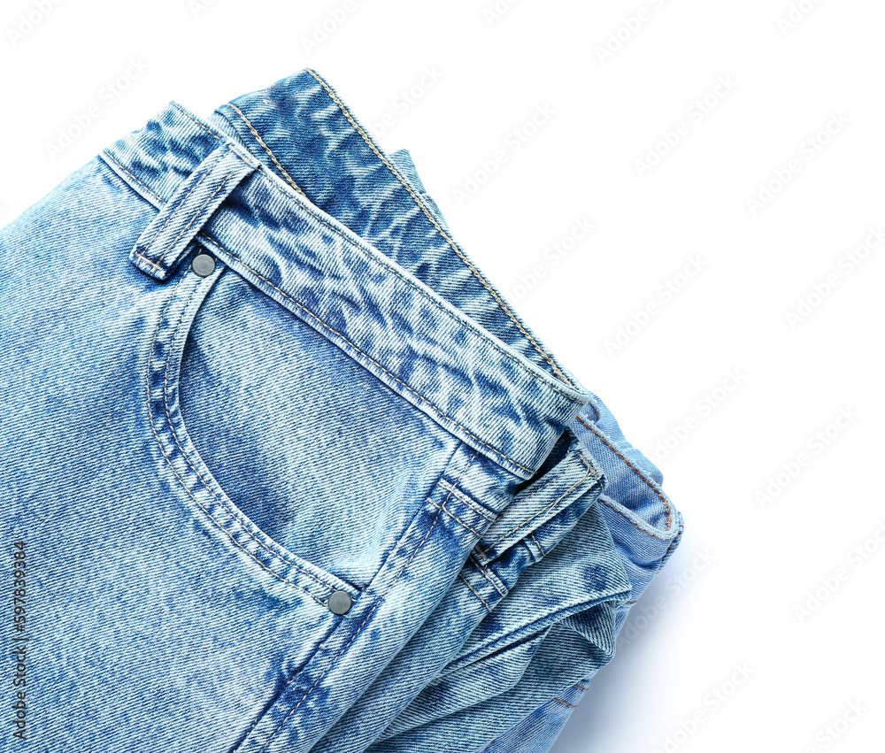 Folded jeans on white background, closeup