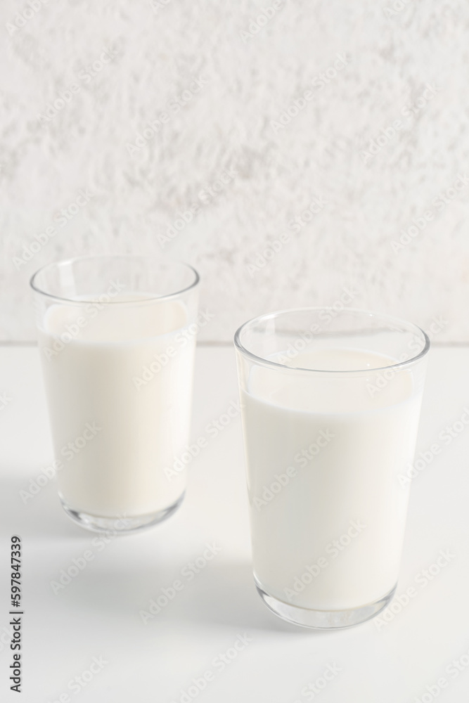 Glasses with fresh milk on white background