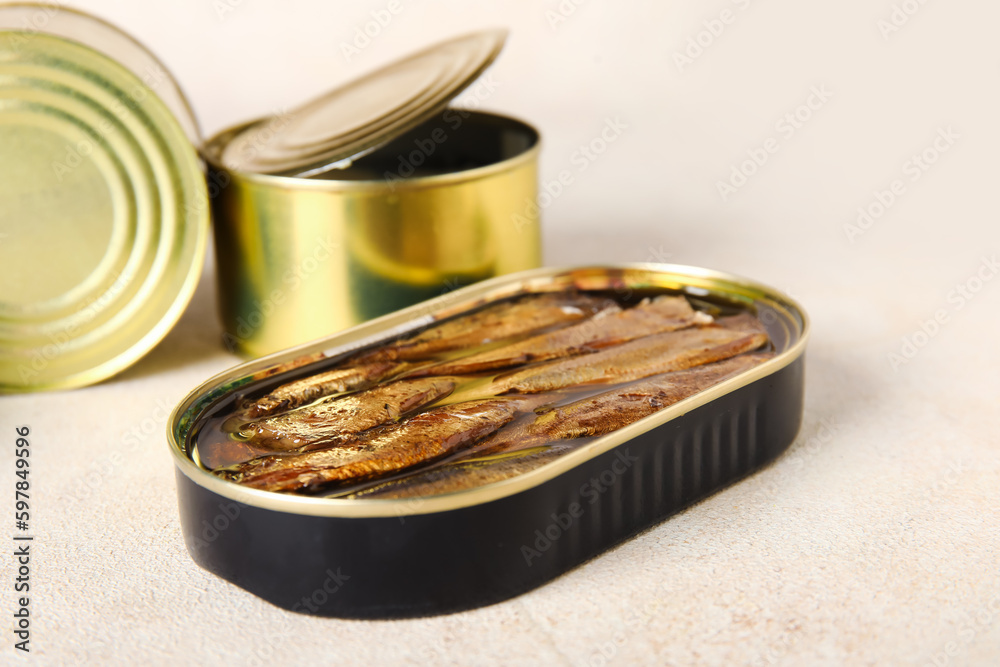 Opened tin cans with sprats in oil on light table