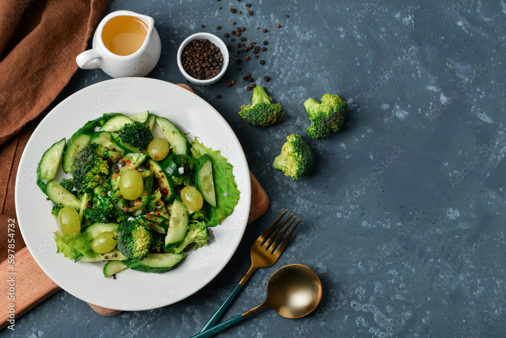 Composition with plate of salad and  ingredients on dark blue background