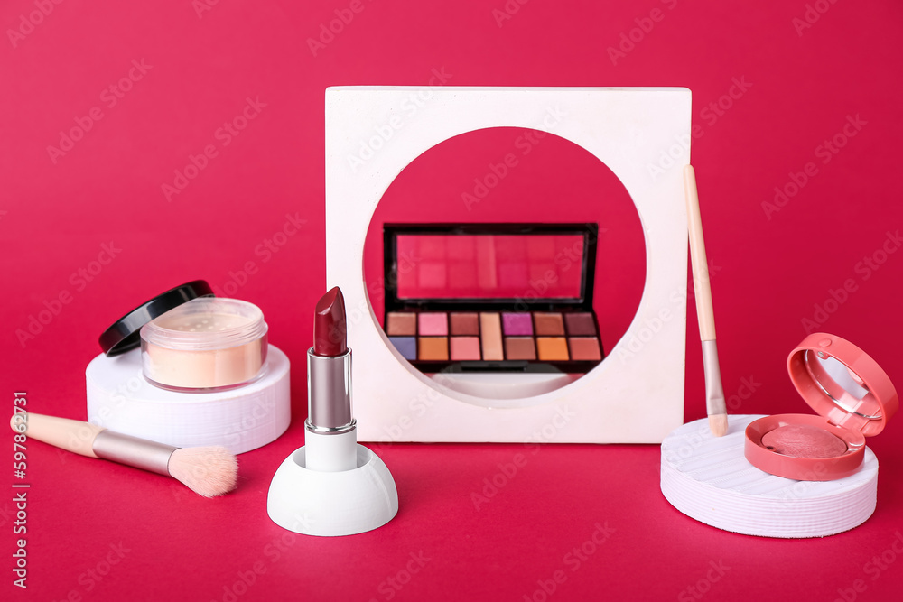 Decorative plaster podiums and cosmetics on red background