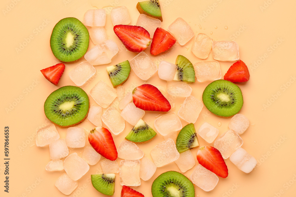 Sliced fresh kiwi with strawberry and ice on orange background