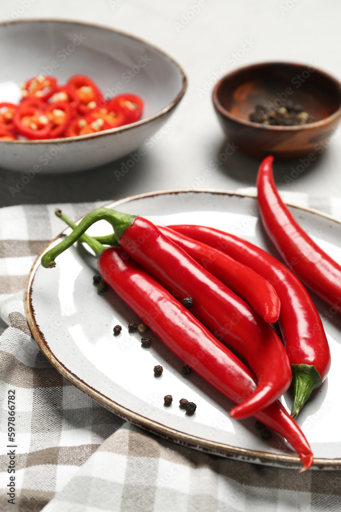 Plate with fresh chili peppers on table, closeup