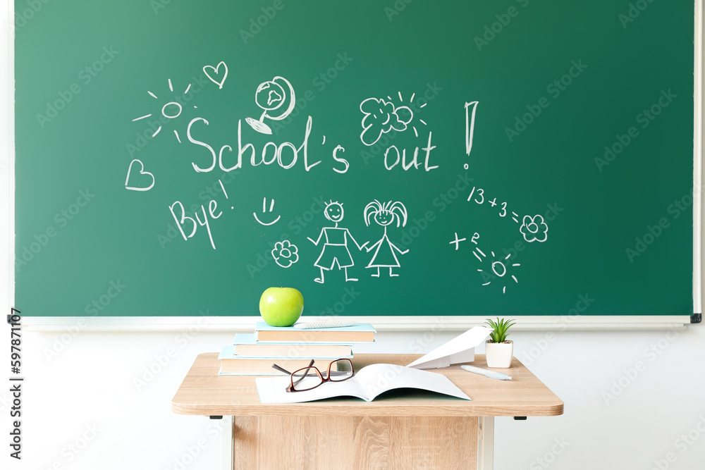 Text SCHOOLS OUT with drawings on blackboard in classroom