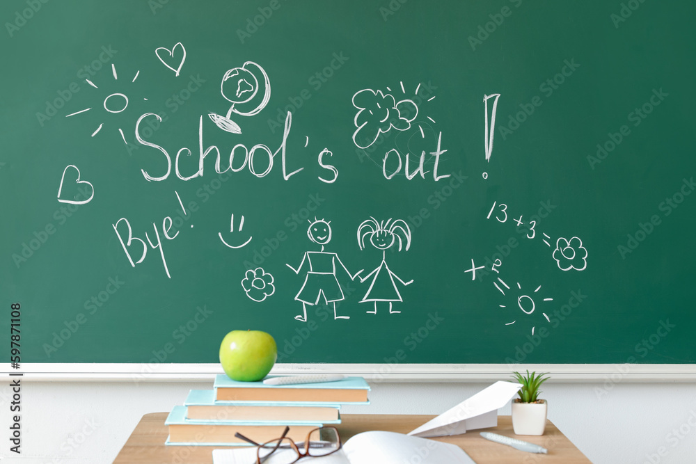 Text SCHOOLS OUT with drawings on blackboard in classroom