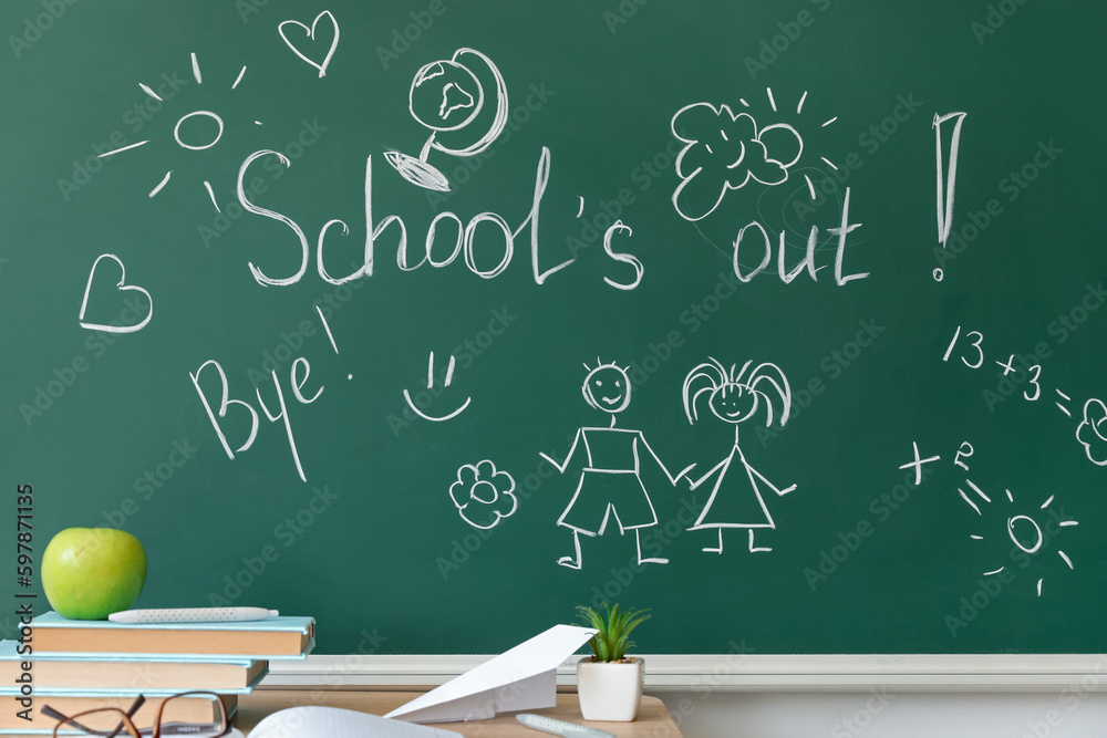 Text SCHOOLS OUT with drawings on blackboard in classroom