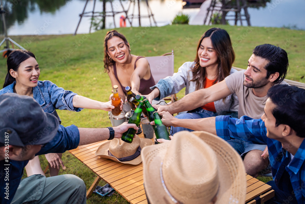 Group of diverse friend having outdoors camping party together in tent. 