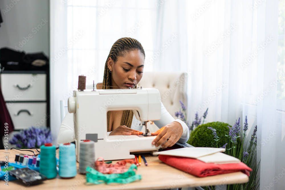 African American women fashion designer working in a tailoring atelier. 