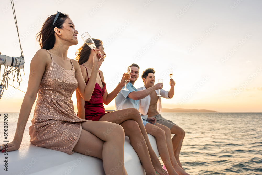 Group of diverse friends drink champagne while having a party in yacht. 