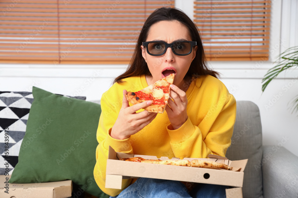 Shocked young woman in 3D glasses with tasty pizza watching film on sofa at home