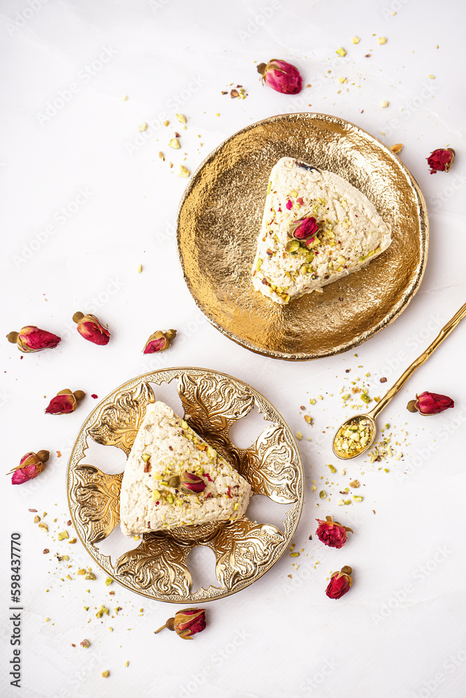 Plates with pieces of tasty Tahini halva on white background