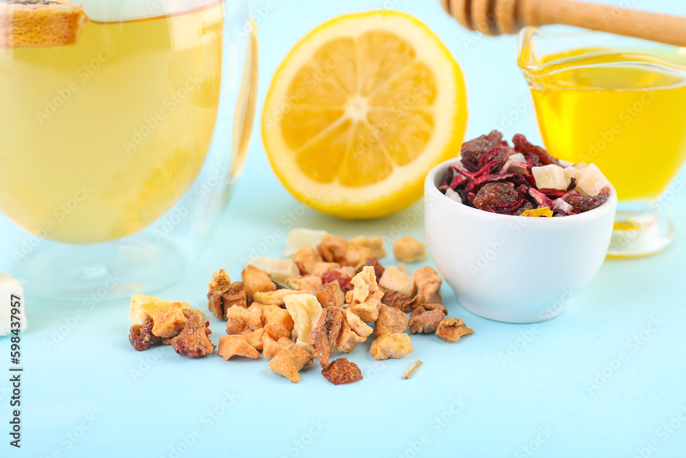 Bowl with dried fruit tea, sugar and honey on blue background, closeup