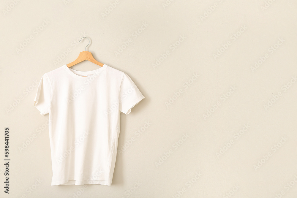 White t-shirt hanging on grey wall