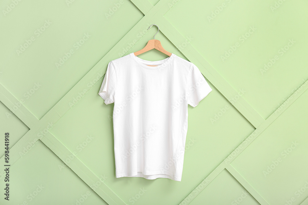 White t-shirt hanging on green wall