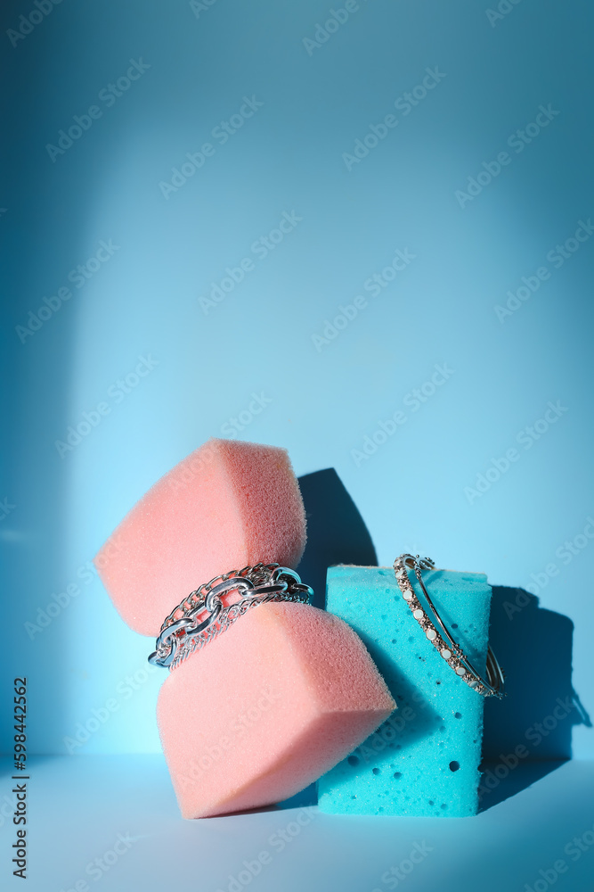 Sponges with jewelry on blue background