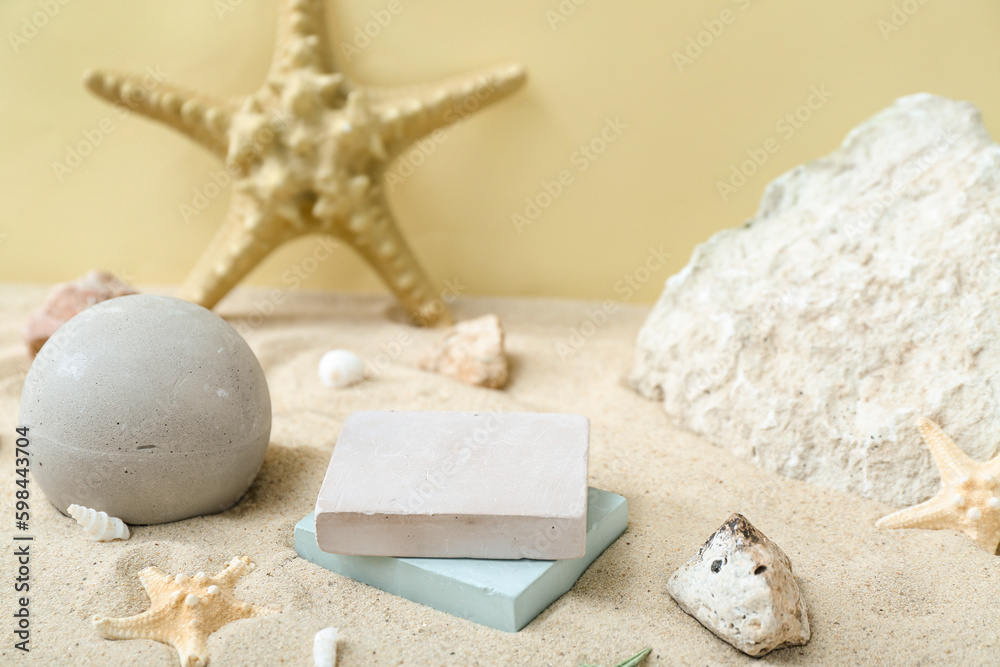 Decorative plaster podiums in sand on light background