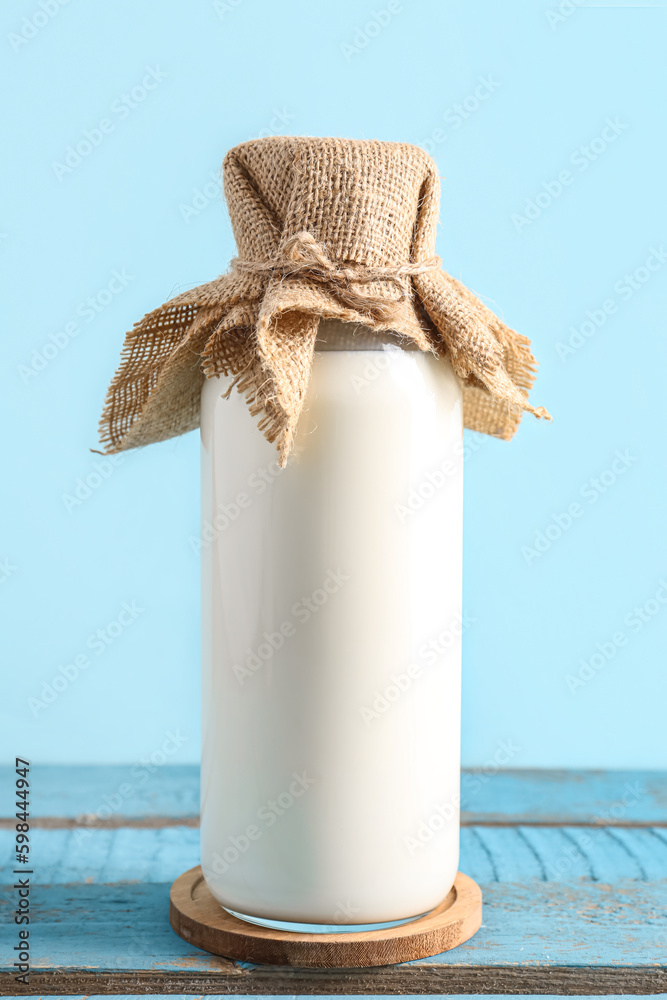 Bottle with fresh milk on blue wooden table