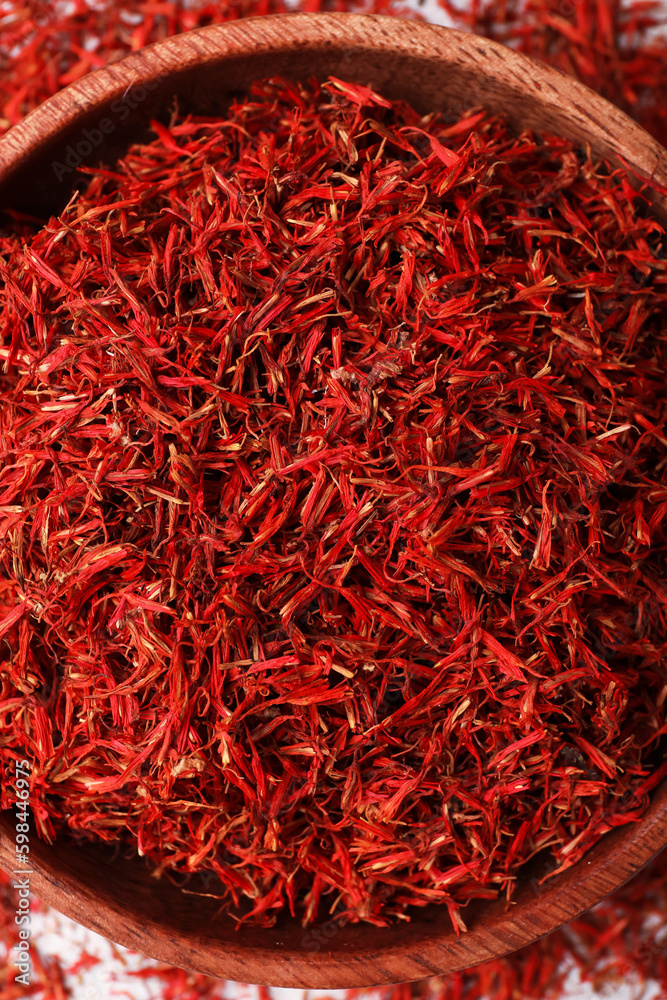 Bowl with pile of saffron as background, closeup