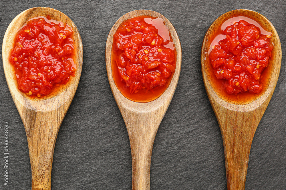 Spoons with tasty tomato sauce on table, closeup