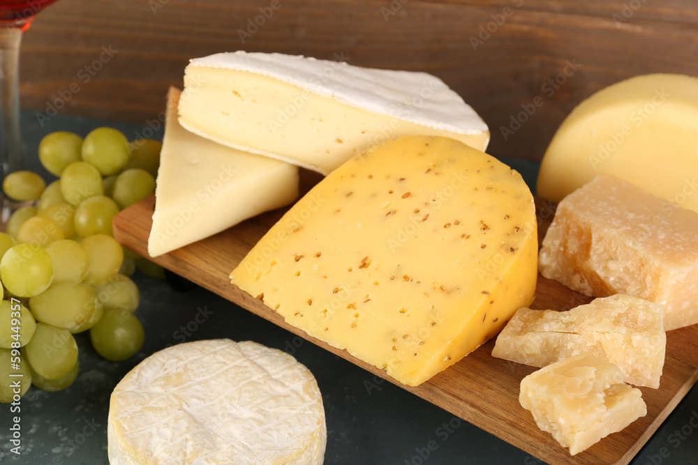 Wooden board with different types of cheese on table