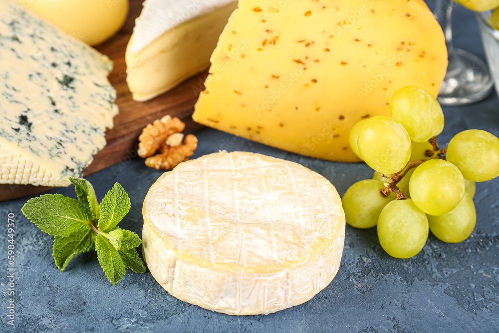 Tasty cheese and grapes on table, closeup